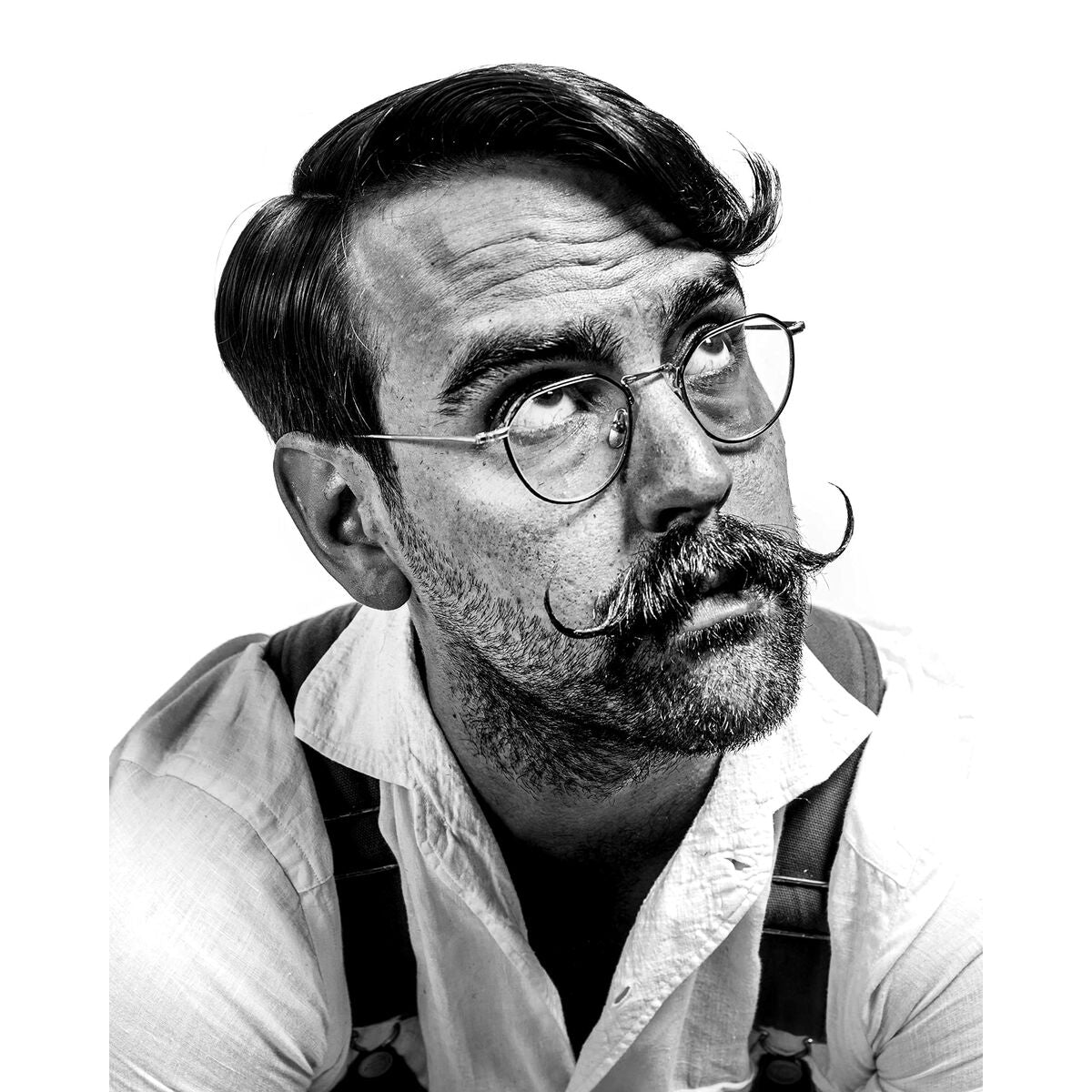Homme avec moustache stylée et lunettes, regardant vers le haut, portrait en noir et blanc