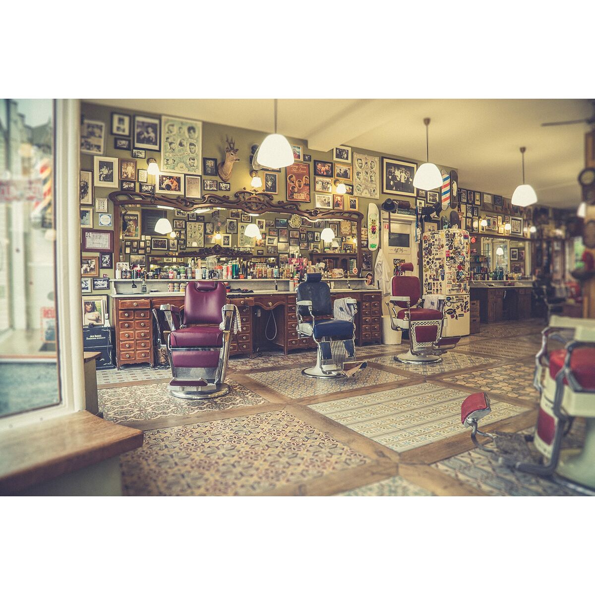 Intérieur d'un salon de coiffure vintage avec chaises rouges et décorations murales artistiques.